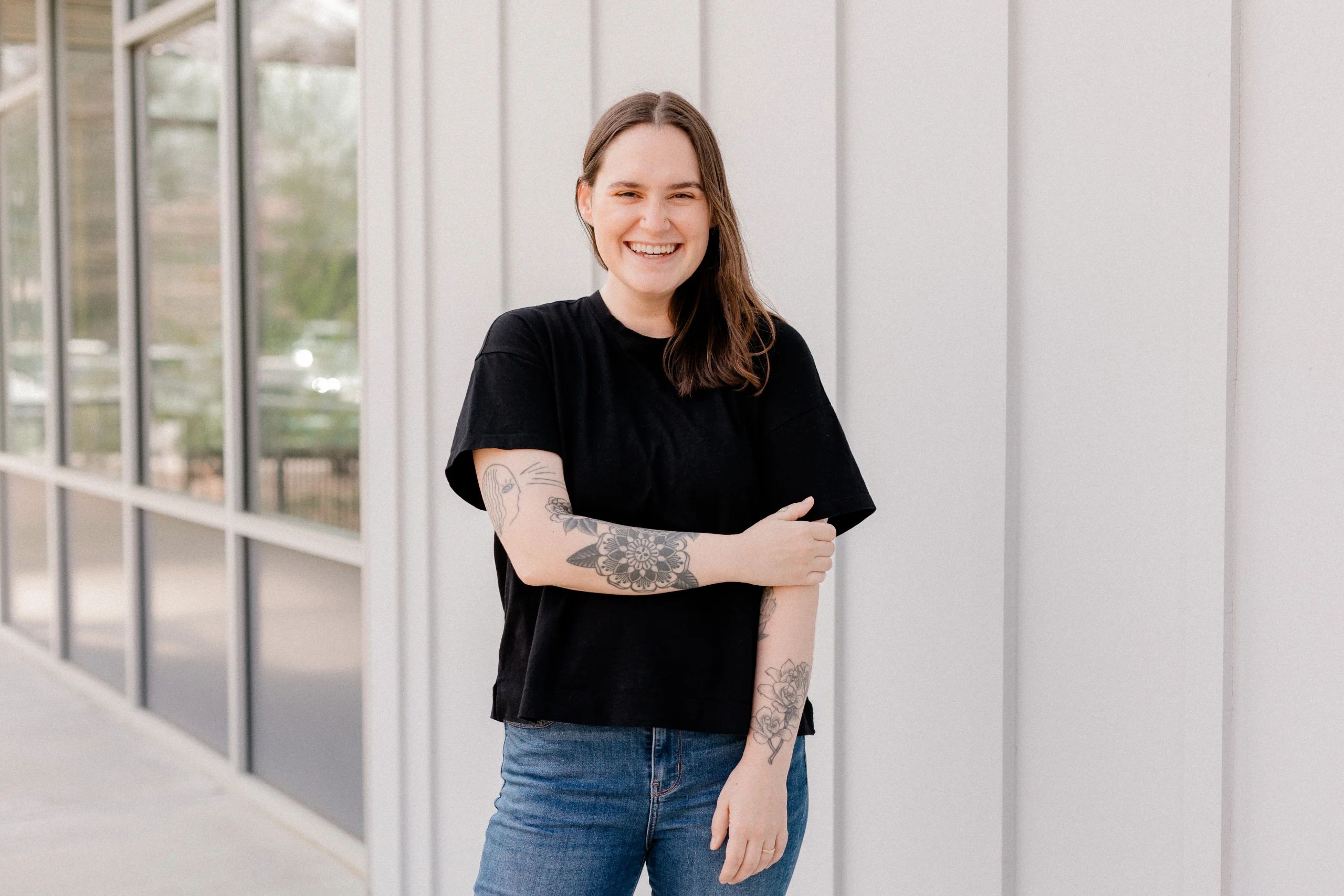 Co-owner Alison stands in front of a white wall laughing
