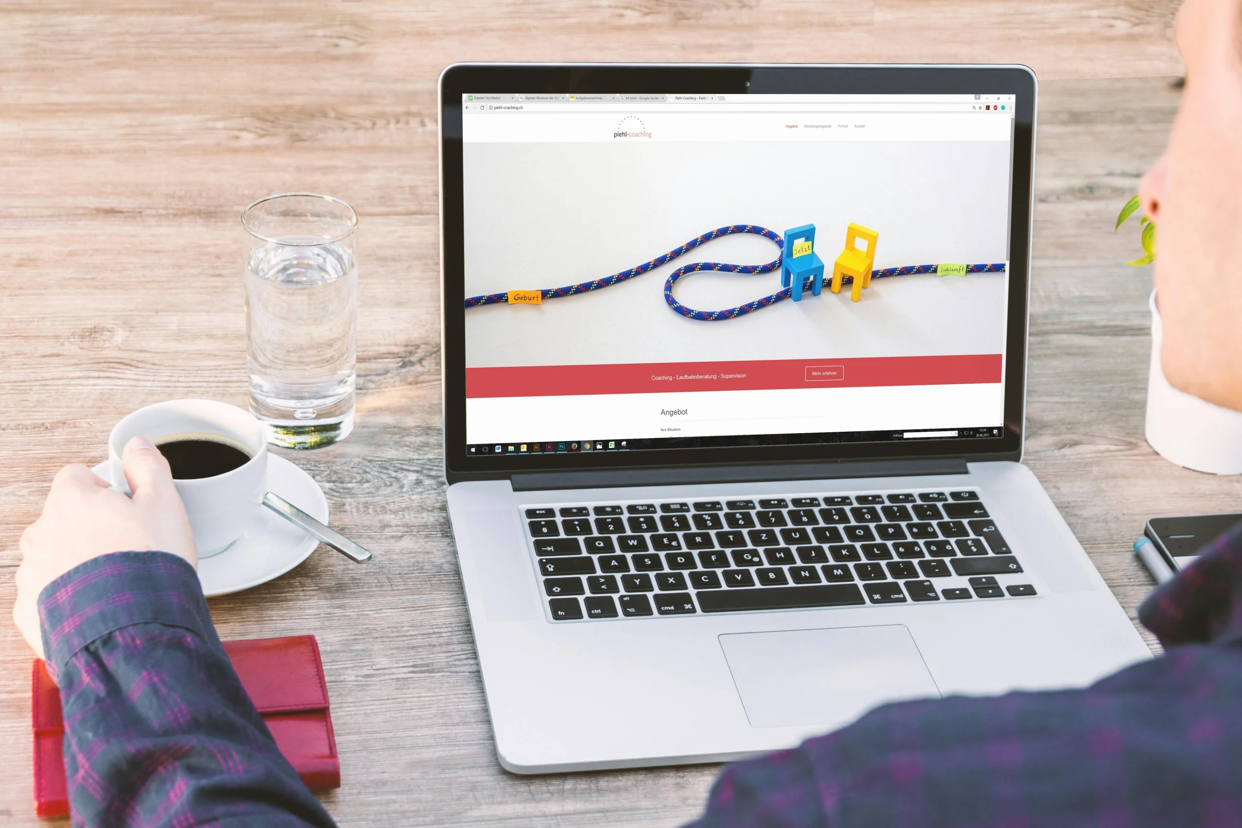 Man sitting at a wooden table drinking black coffee from a mug, looks like he is working on his website page speed.